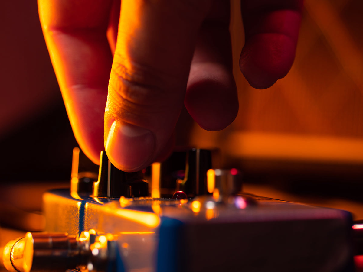 hand adjusting guitar pedal